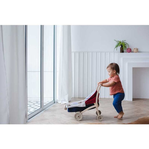 Kid playing PlanToys Doll Stroller