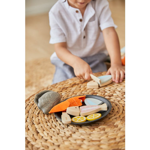 Kid playing PlanToys Seafood Platter