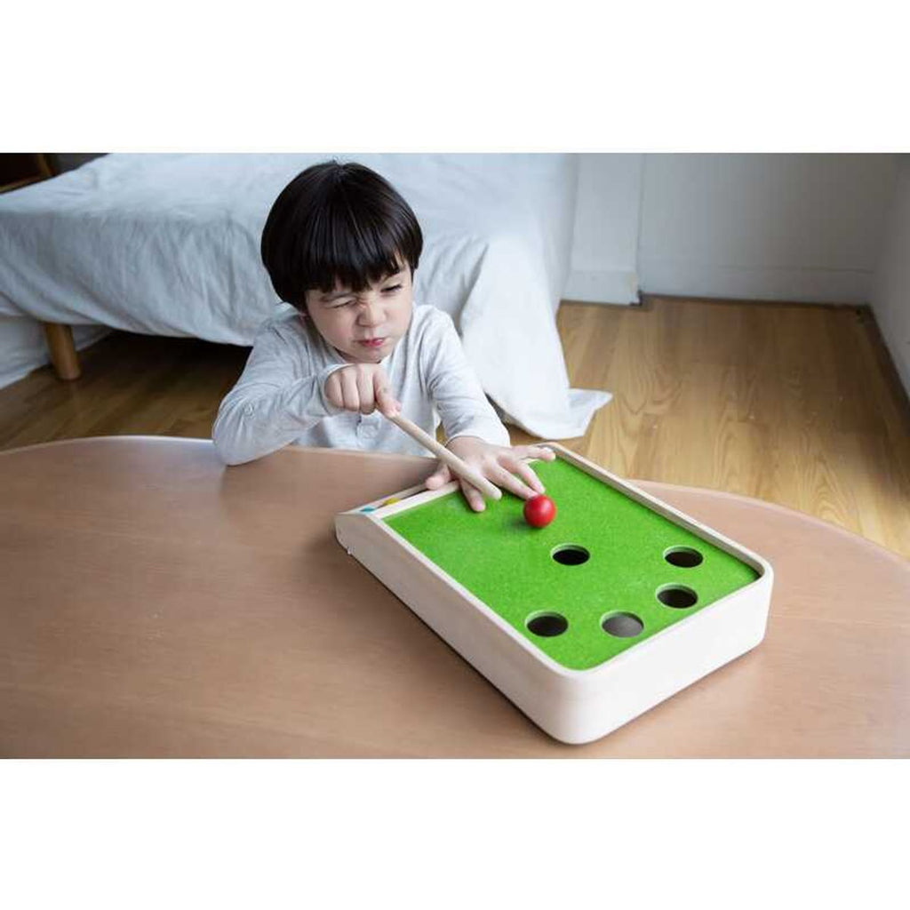 Kid playing PlanToys Ball Shoot Board Game