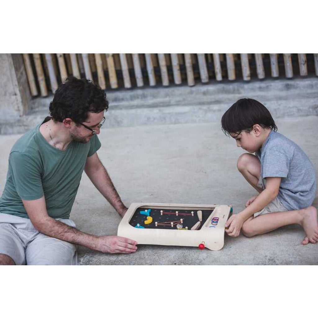 Kid playing PlanToys Pinball