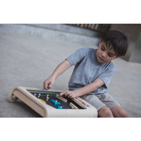 Kid playing PlanToys Pinball