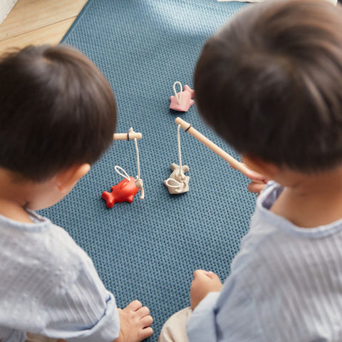 Kid playing PlanToys Fishing Game