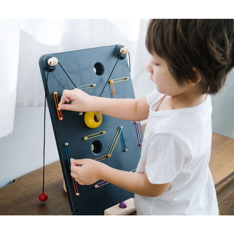 Kid playing PlanToys Wall Ball Game