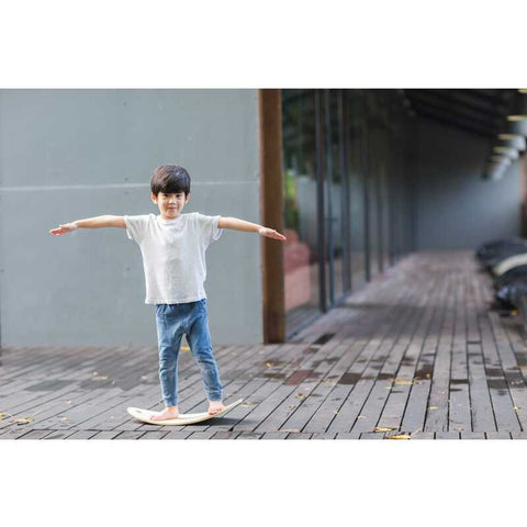 Kid playing PlanToys Balance Board