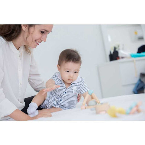 Kid playing PlanToys Triangle Clutching Toy - Pastel Series