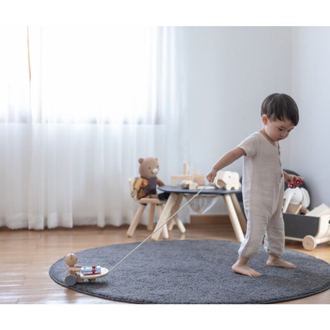 Kid playing PlanToys Pull Along Musical Bear