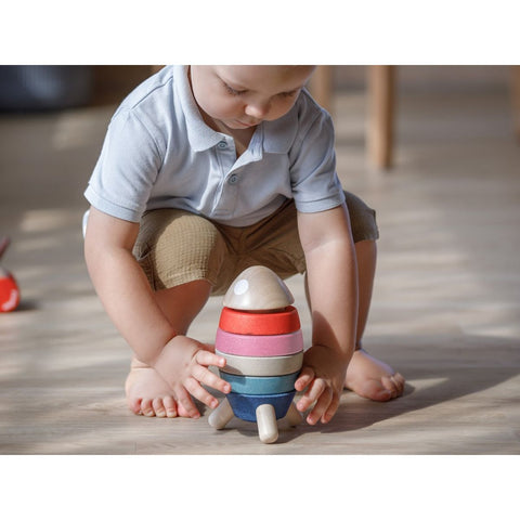 Kid playing PlanToys Stacking Rocket - Orchard Series