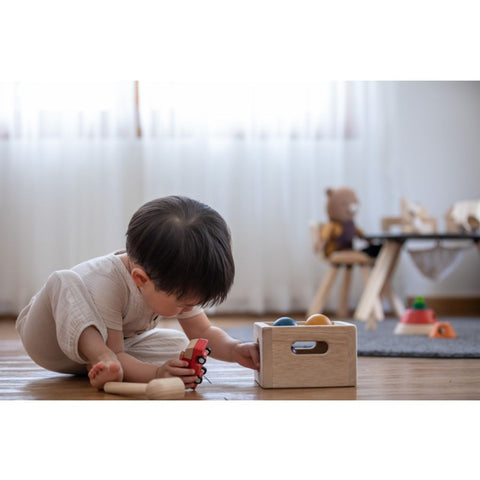 Kid playing PlanToys Punch & Drop - Orchard