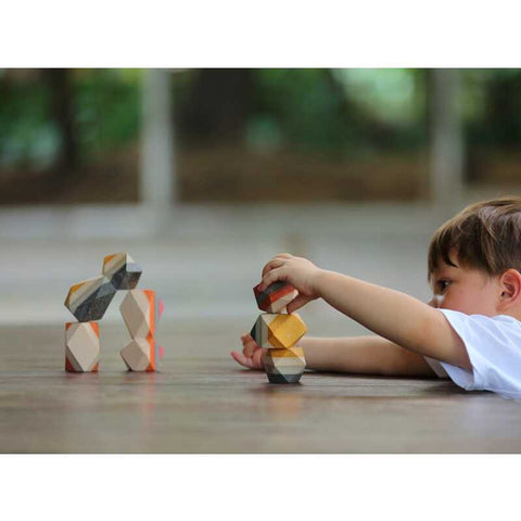 Kid playing PlanToys Geo Stacking Rock