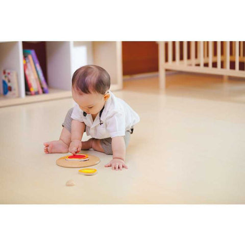 Kid playing PlanToys Chicken Puzzle