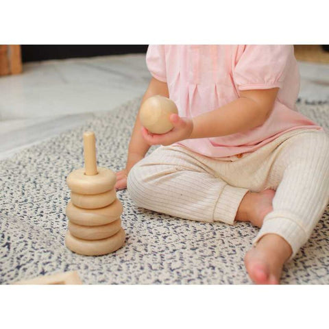 Kid playing PlanToys Stacking Ring - Natural