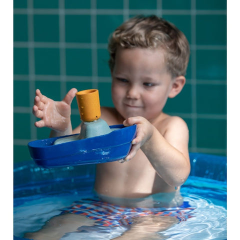 Kid playing PlanToys Tugboat