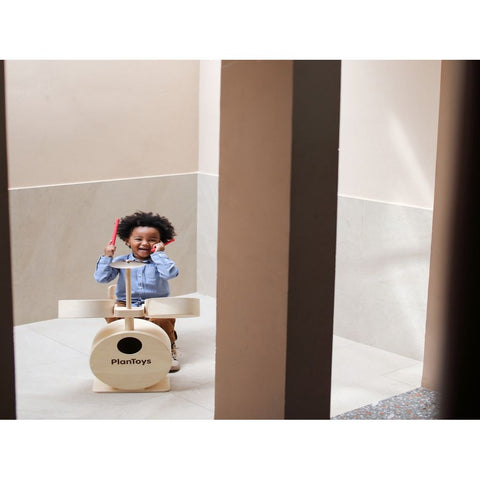 Kid playing PlanToys Drum Set