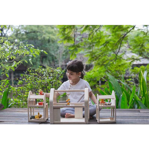 Kid playing PlanToys Slide N Go Dollhouse