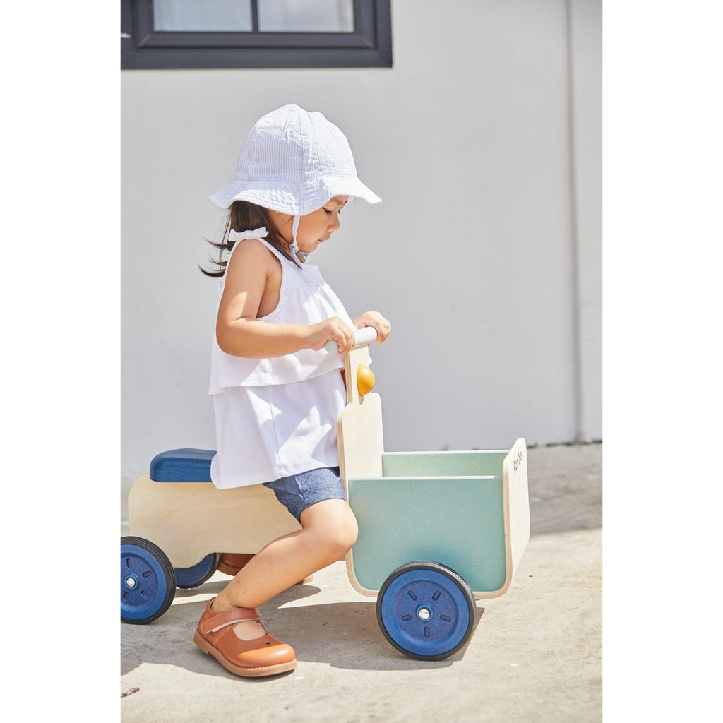 Kid playing PlanToys Delivery Bike - Orchard Collection