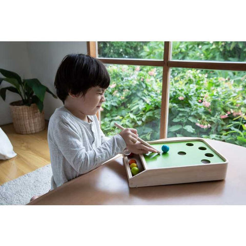 Kid playing PlanToys Ball Shoot Board Game