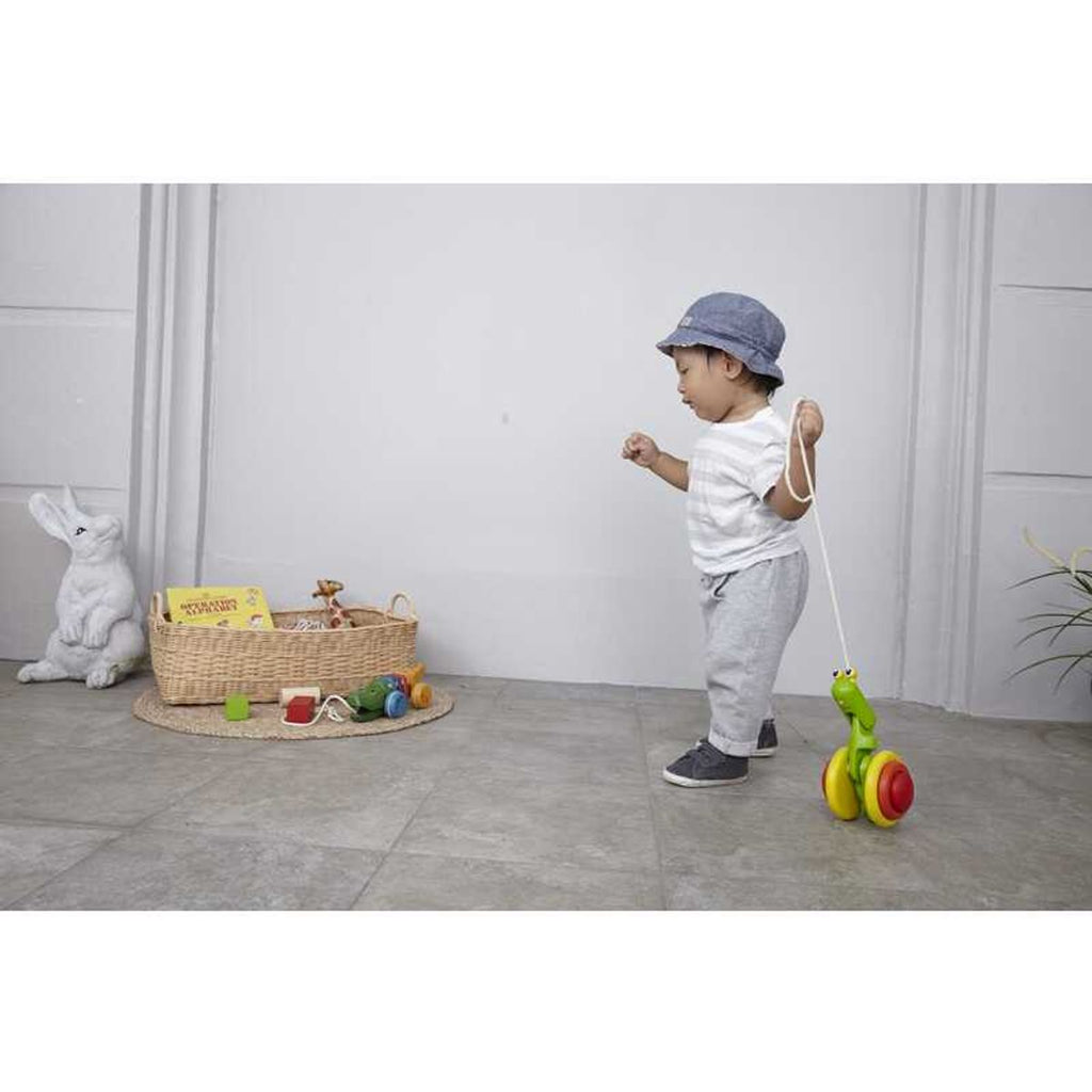 Kid playing PlanToys Pull Along Snail