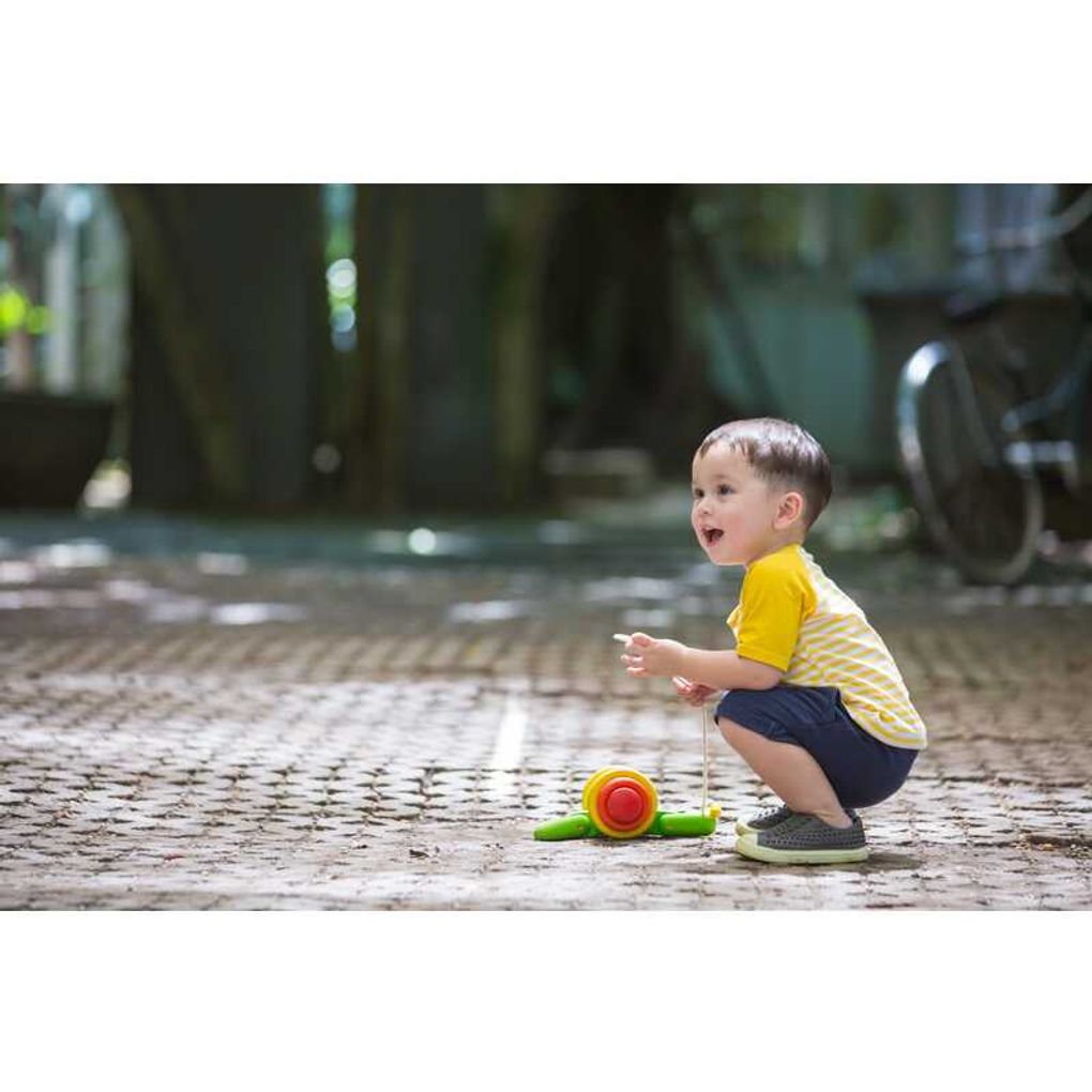 Kid playing PlanToys Pull Along Snail