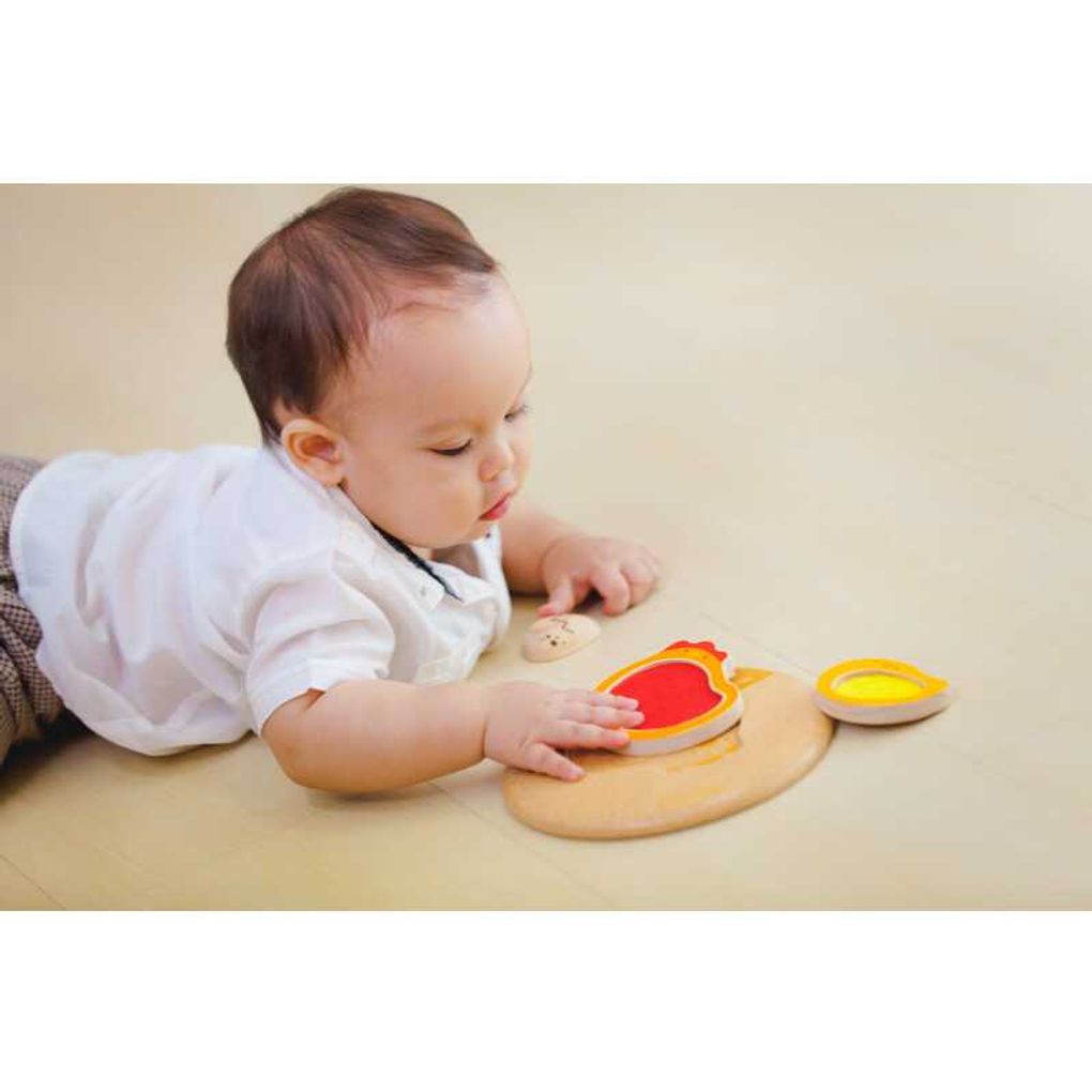 Kid playing PlanToys Chicken Puzzle
