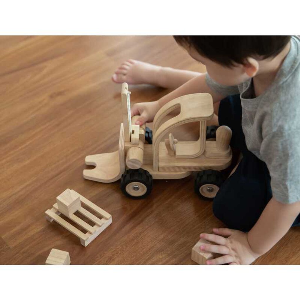 Kid playing PlanToys Forklift